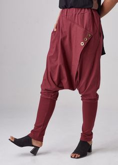 "🚚..ALL ORDERS ARE SHIPPED VIA DHL EXPRESS MAIL Relaxed fit dropped-crotch pants in red. Asymmetric crossover fabric panel at front and back with 3 buttons front detailed. Elastic waistband and two hand pockets at side seam. Roll up the cuffed hem for an utlra relaxed look! * Pull-on style * Drop-crotch style * 2\" Elastic waistband * Side seam pockets * Wide cuffed hem Measurements approximately: Waist : 26\" (66 cm) stretching to 48\" (122 cm)-elastic material Hips : 50\" (122 cm) Outseam: 38 Red Cotton Harem Pants For Fall, Baggy Red Harem Pants With Pockets, Red Baggy Harem Pants With Pockets, Red Cotton Bottoms With Button Closure, High Waist Red Harem Pants With Pockets, Red High-waist Harem Pants With Pockets, Red High Waist Harem Pants With Pockets, Red Baggy Long Pants, High Waist Red Cotton Harem Pants