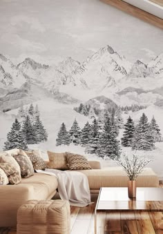 a living room with a couch, coffee table and mountain mural on the wall behind it