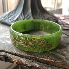 a green bracelet sitting on top of a wooden table