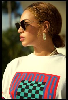 a close up of a person wearing sunglasses and a t - shirt with checkered design