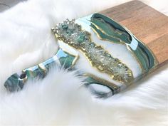 a green and white marbled object on a wooden board with fur around it's edges