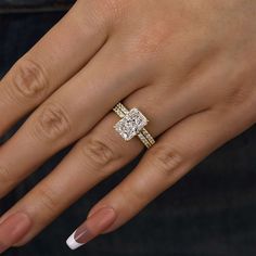 a woman's hand with an engagement ring and two wedding bands on her fingers