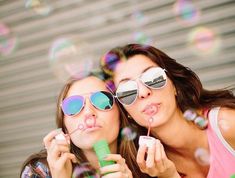 two young women blowing bubbles in front of a quote from art costello on life