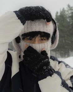 a young man in winter gear covers his face