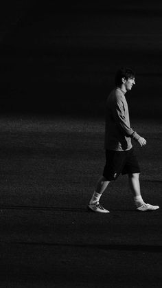 black and white photograph of a man walking in the dark