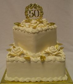 a wedding cake with white frosting and gold decorations