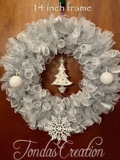 a white christmas wreath hanging on a door