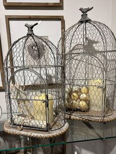 two bird cages filled with food sitting on top of a table