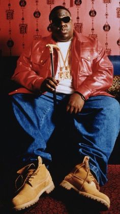 a man sitting on top of a blue couch in front of a red and white wall