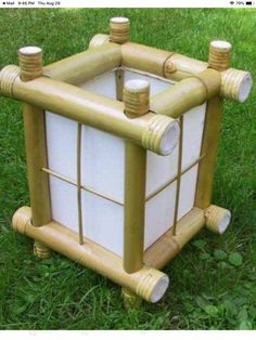 a toy house made out of wood and glass blocks on the grass in front of some trees