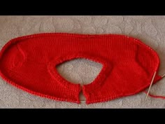 a red knitted object laying on the floor