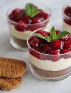 three desserts with cherries and cookies on a table