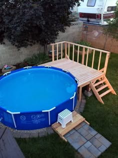 an above ground swimming pool with steps leading up to it and a deck in the back yard