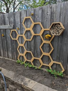 a beehive made out of honeycombs on the side of a fence