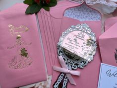 pink and gold wedding stationery on display with flowers in the background, including an ornament