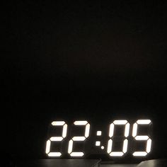 the digital clock is lit up in the dark with two different numbers on each side