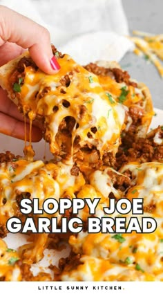 a person holding up a slice of sloppy joe garlic bread