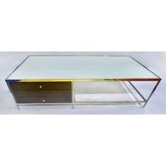 a glass and metal coffee table with two drawers on one side, in the shape of a rectangle