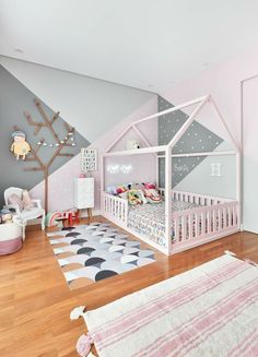 a child's room with pink and grey walls, white furniture and rugs