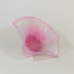 a pink glass vase sitting on top of a white table