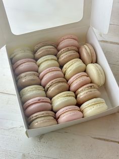 a box filled with lots of pink and white macaroons