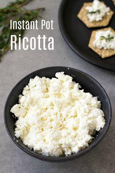 two black plates with crackers and cottage cheese on them, next to each other