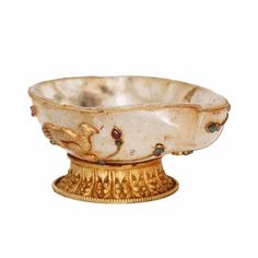 a white and gold bowl sitting on top of a table