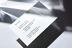 a close up of a business card on top of a white table with silver foil