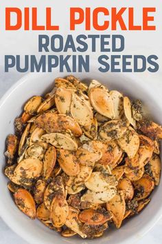 roasted pumpkin seeds in a white bowl with the title, dill pickle roasted pumpkin seeds