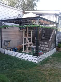 a backyard area with a fenced in enclosure and various items on the ground outside