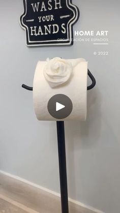 a roll of toilet paper sitting on top of a black pole