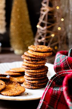 a stack of crackers sitting on top of a white plate next to a pile of cookies