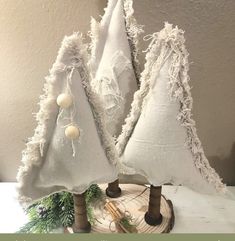 three small white christmas trees on a table