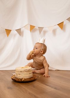 a baby sitting on the floor with a cake in front of her and eating it