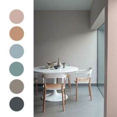 a dining table with four chairs in front of it and color swatches on the wall