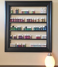 a wall mounted shelf filled with lots of different types of medicine bottles on top of a wooden table