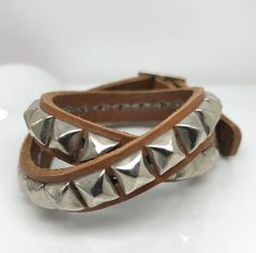 Men’s double wrap bracelet made from real leather.   Specifications :- Real leather- 12 mm wide (a little less than 1/2”)- Adjustable length- Total length 17”Available in 3 colors : light brown, dark brown, and white. Trendy Adjustable Spiked Bracelets, Silver Leather Bracelets With Spikes, Silver Leather Bracelet With Spikes, Adjustable Spiked Leather Bracelets, Adjustable Silver Leather Bracelet With Rivets, Adjustable Leather Bracelet With Spikes, Adjustable Silver Bracelet With Spikes, Spike Bracelet, Double Wrap Bracelet