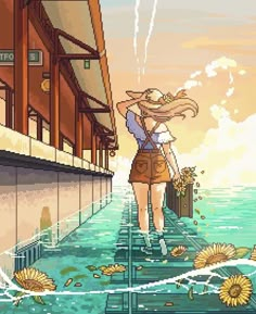 a woman walking down a walkway next to the ocean in front of a building with sunflowers on it