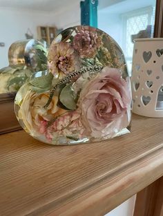 a heart shaped mirror sitting on top of a wooden table next to a candle holder