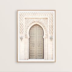 an ornate door is framed on the wall above a white bench in front of it