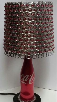 a lamp made out of soda bottles with chains on the base and a coca - cola bottle in the bottom