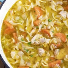 chicken noodle soup with carrots, celery and noodles in a pot