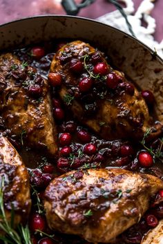 chicken with cranberry sauce and herbs in a pan