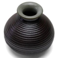 a black vase sitting on top of a white table