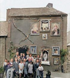 a group of people standing in front of a building with pictures on the side of it