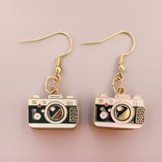 Add some whimsy and retro fun to your wardrobe with these cool "old school" style camera dangle earrings. They are lightweight, easy to wear, and make awesome statement pieces. Earring hooks are 925 sterling silver, hypoallergenic, and come with rubber earring backs/stoppers to ensure earring stays in place. Camera charms are made of alloy and have the design on one side (back of charm is gold). Please note each pair of earrings is personalized and made to order. As a result, there may be slight variations in color and/or finish.  RETURNS / EXCHANGE POLICY 📷Your satisfaction is important to me. If there is a concern with you order, please contact me.  📷No refunds will be issued for misspelling of names provided to me or if your event has been cancelled 📷Since all items are personalized Retro Circular Earrings For Gift, Camera Clay Earrings, Camera Earrings, Silver Retro Clip-on Earrings For Gift, Camera Charm, Retro Earrings, Cute Camera, Old School Style, Retro Accessories