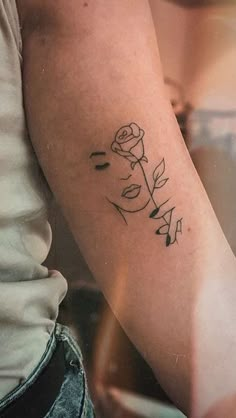 a woman with a rose tattoo on her arm