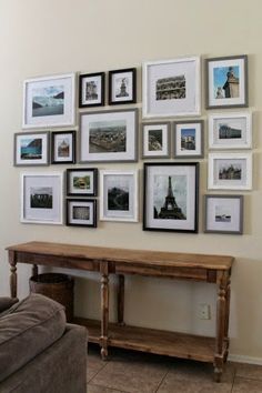 a living room with pictures on the wall and a couch in front of it,