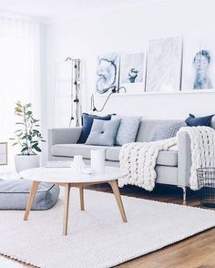 a living room filled with furniture and pictures hanging on the wall above it's coffee table