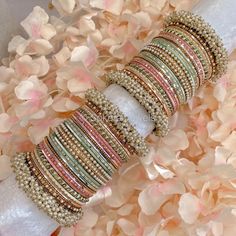 a bunch of bracelets that are sitting on some flowers